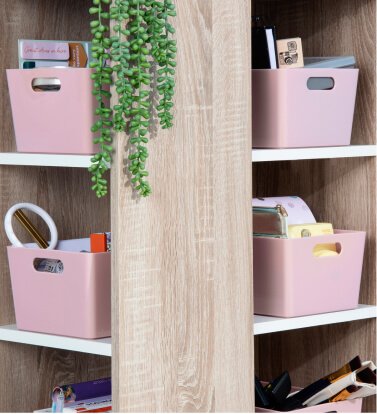Pink storage boxes in a shelving unit.