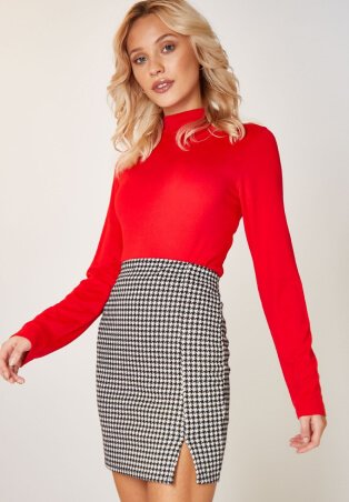 Woman wearing red top and black checkered skirt.