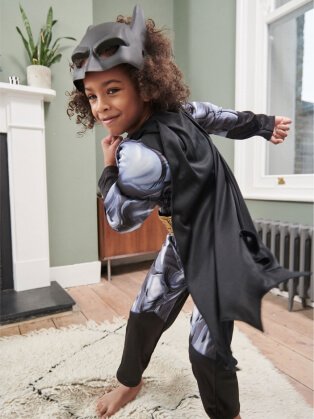 Child wearing super hero costume.