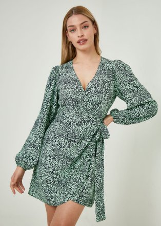 Woman wearing a green floral wrap dress.