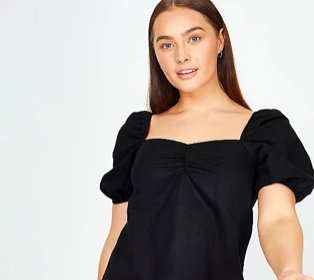 Woman poses wearing black volume sleeve ruched blouse.