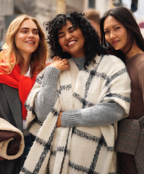 Three women wearing knitwear and scarves.