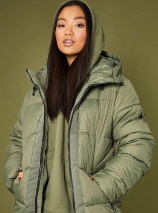 Woman wearing Khaki puffer jacket and khaki hoodie.