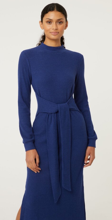 A woman wearing a navy ribbed belted midi dress.