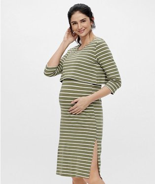 Woman poses smiling with hand on bump wearing MAMALICIOUS maternity khaki striped nursing dress.