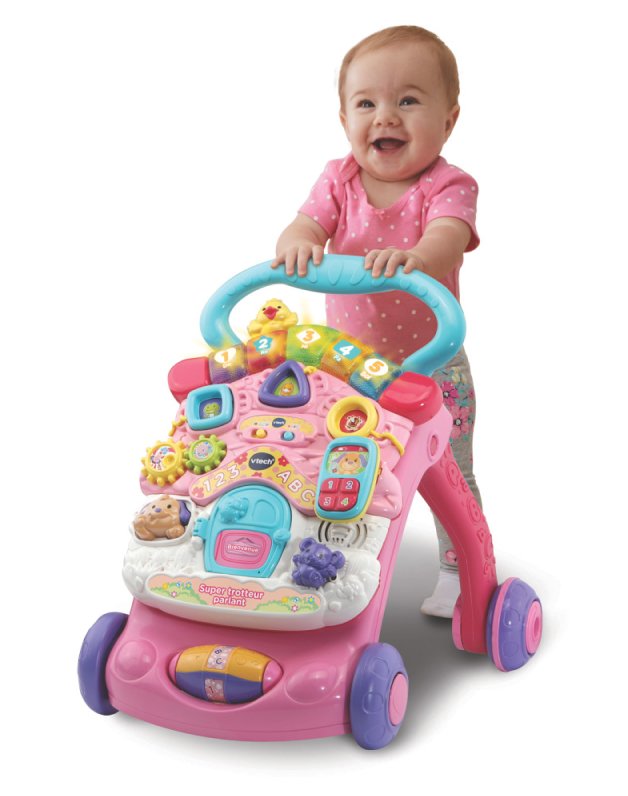 A baby walking with a pink Vtech First Steps baby walker