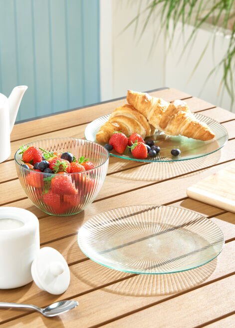 Some berries and a croissant on a table.