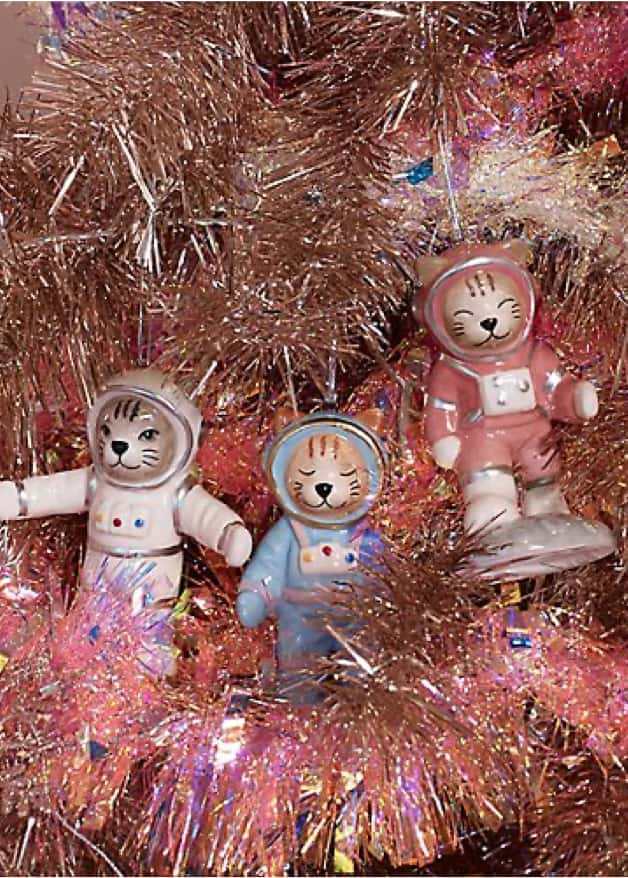 Gold-tone Christmas tree decorated with pink tinsel and animal astronaut baubles.