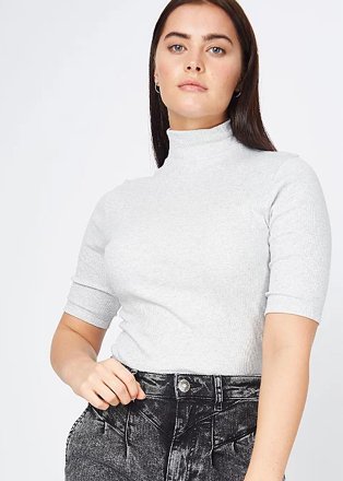 Brunette woman poses with hand in pocket wearing grey marl funnel neck sporty fitted t-shirt and grey acid wash jeans.