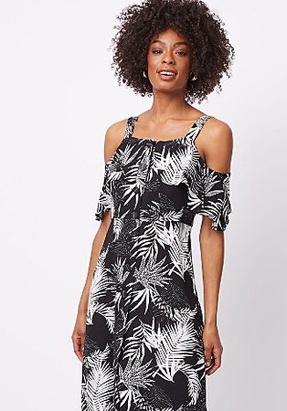 Woman wearing a black leaf print dress with cold shoulders