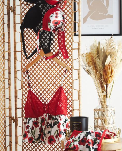 A selection of black lace and red and white floral lingerie in a bedrooom