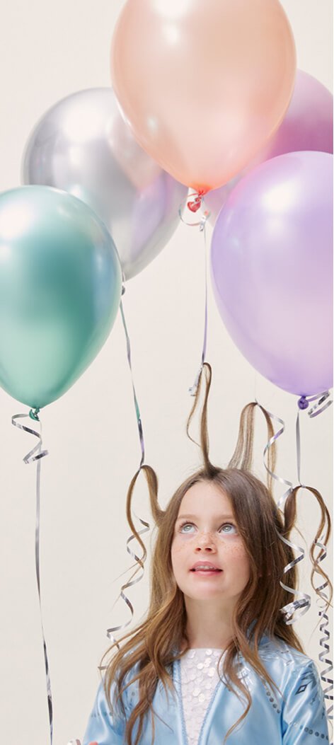 A girl in a Frozen costume with pastel balloons tied to her hair