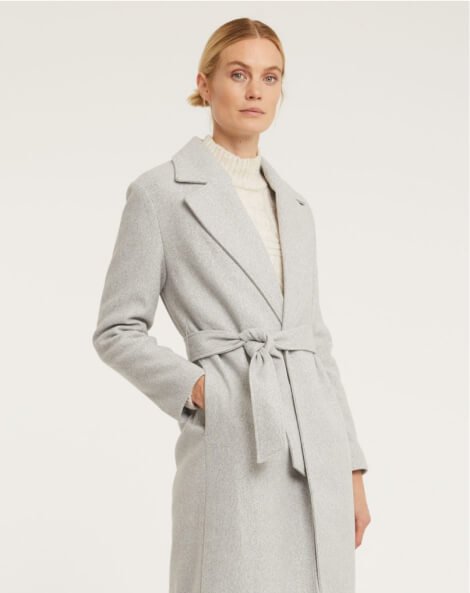 A woman wearing a grey longline jacket.