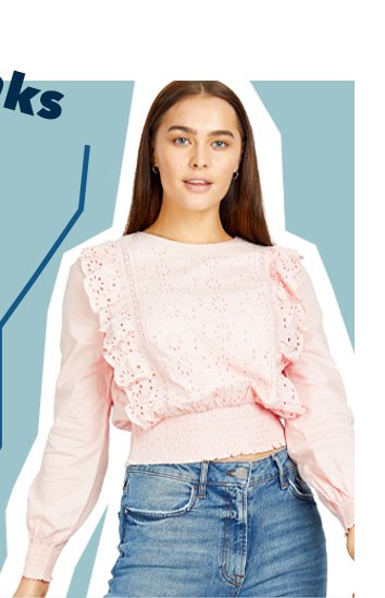 Woman poses wearing pink embroidered frill trim blouse and blue mid wash denim jeans.