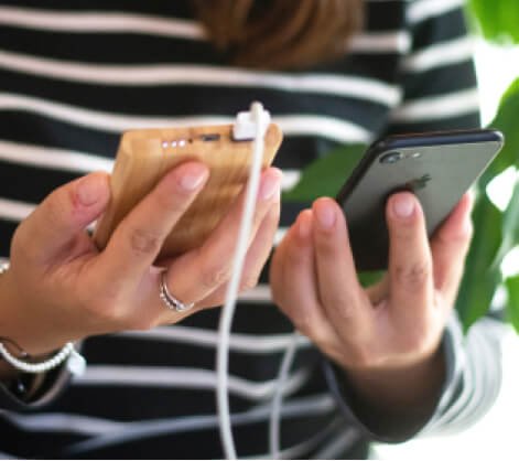 Woman holding mobile phone and power bank.