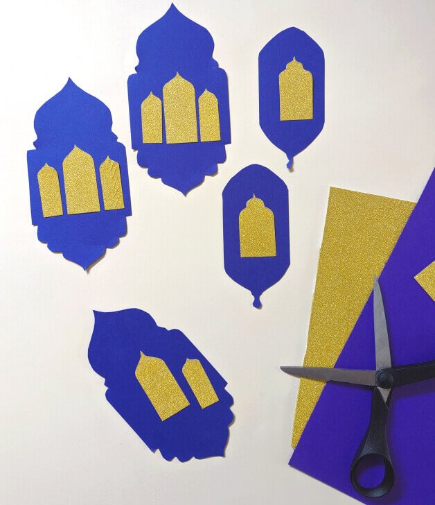 A selection of DIY Ramadan decorations made from purple and gold glitter paper