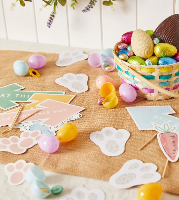 An Easter egg hunt kit and a wicker basket full of chocolate eggs