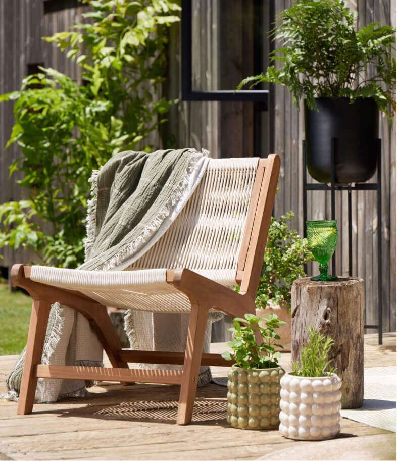 A wooden garden chair with a cream woven detail.
