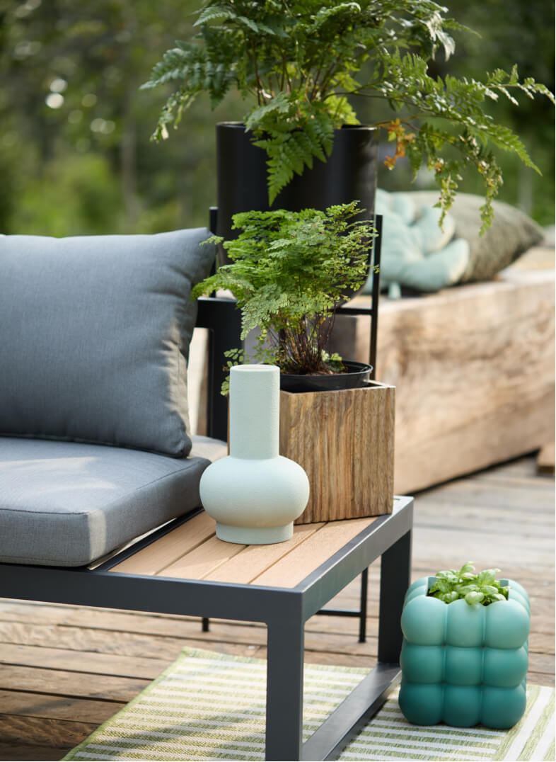 A close up of a garden patio with blue, green and wooden planters.
