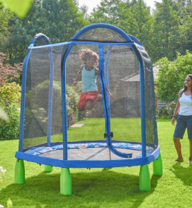 A child jumping on a blue and green trampoline