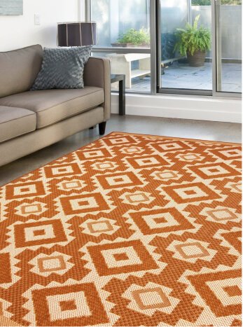 Relay Aztec terracotta rug next to a beige sofa.