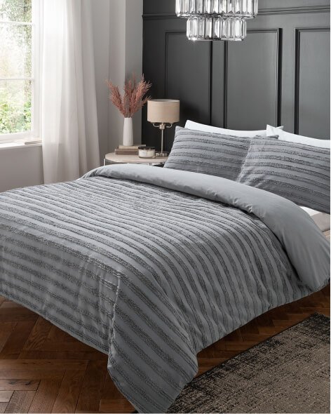 Grey luxury tufted cotton duvet set on a double bed.