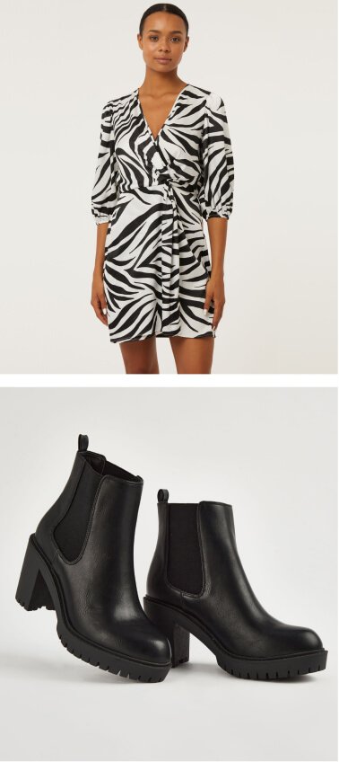 A woman in a mono zebra print twist front mini dress and black heeled ankle boots.