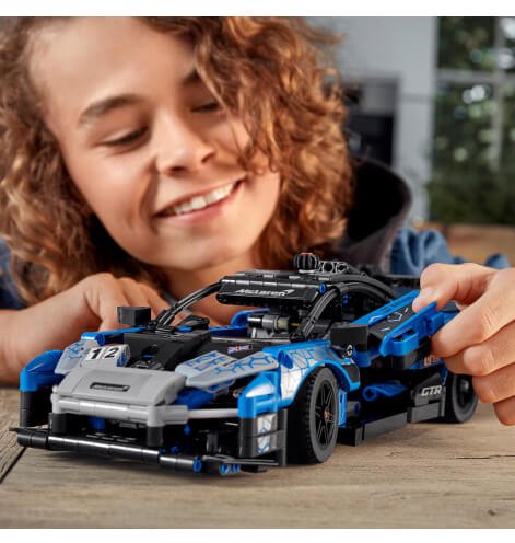 A child playing with a LEGO car