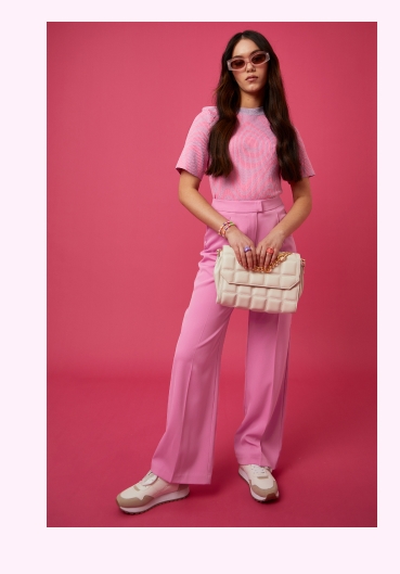 Girl wearing pink knitted co-ord, girl wearing jeans and knit pink top.