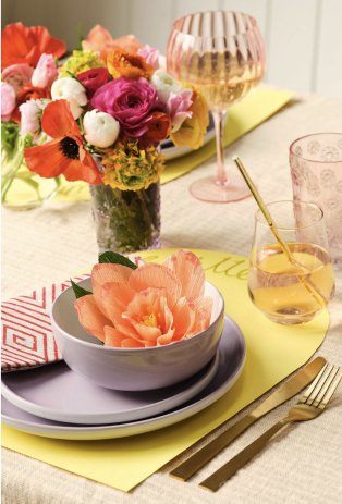 Table setting with flowers, plates, glasses.