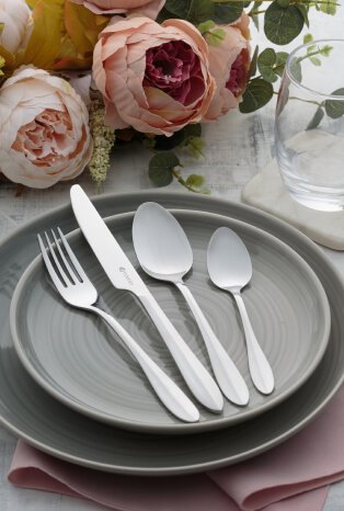 A table with grey dinnerware and silver-tone cutlery set.