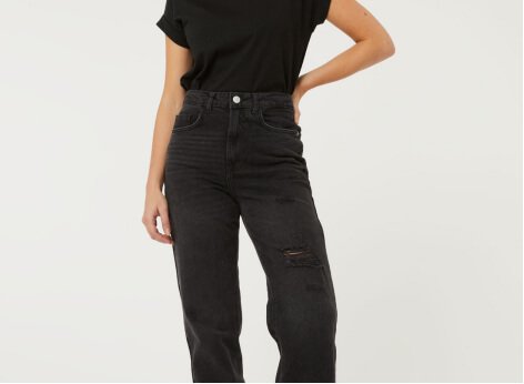 A woman wearing a black t-shirt with baggy black jeans