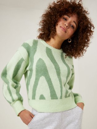 Woman wearing green patterned jumper.