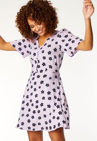 Woman wearing lilac floral dress.