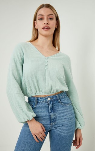 Woman wearing pastel green top and jeans.