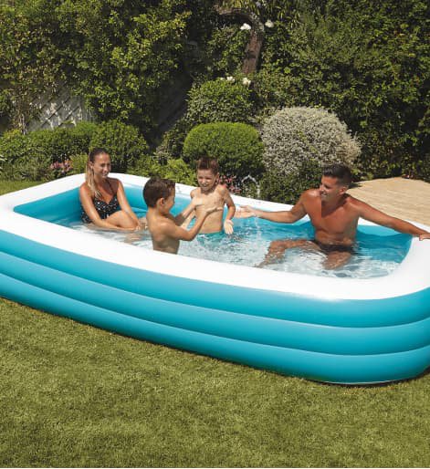 Paddling pool with adults and children in it.