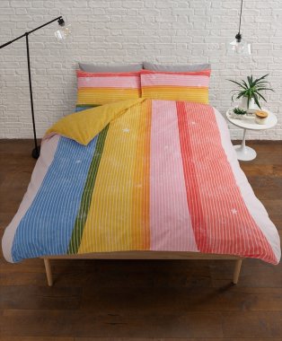 Double bed features multicoloured stripe print duvet set with white side table.