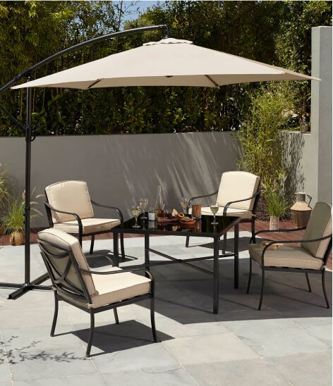 A cream and black garden table, umbrella and chair set.