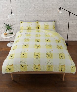 Bed with Winnie The Pooh print duvet.