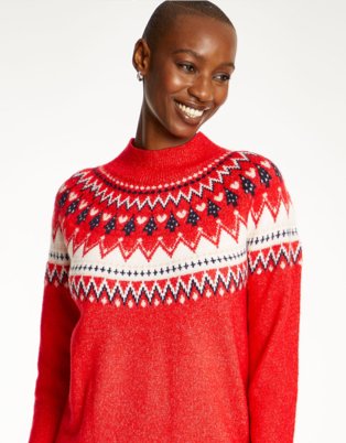 Woman poses smiling wearing red Fairisle high neck Christmas jumper.