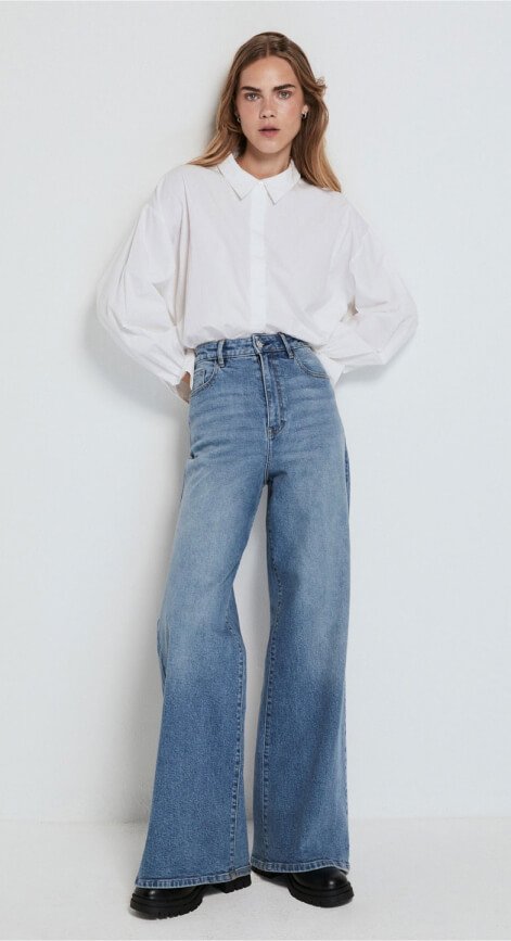 Woman wearing white shirt and light blue jeans.