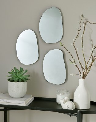 Bathroom wall with mirrors and vase.
